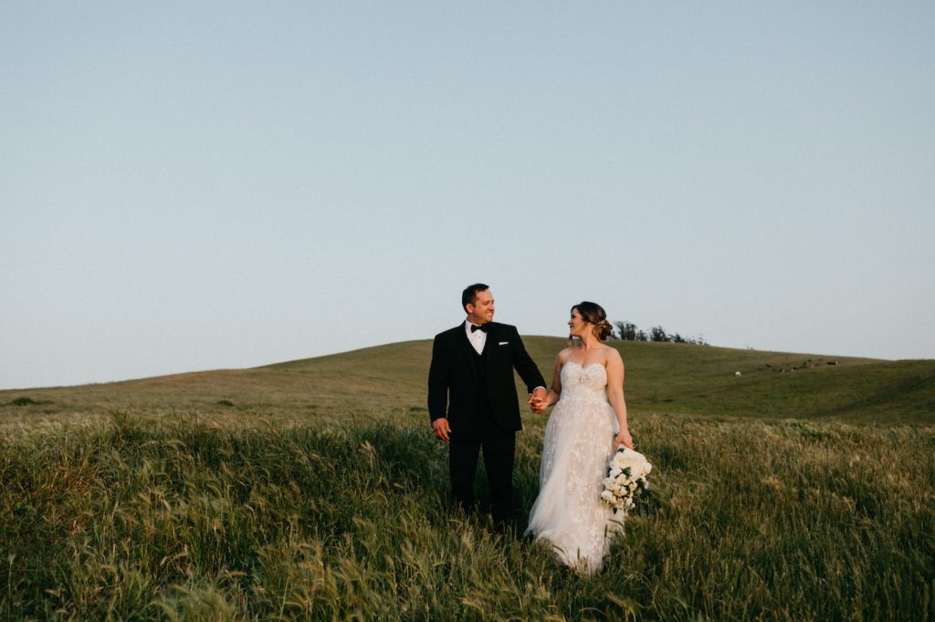 Bride and groom walking through hills at sunset at Olympia's Valley Estate in Petaluma, CA.